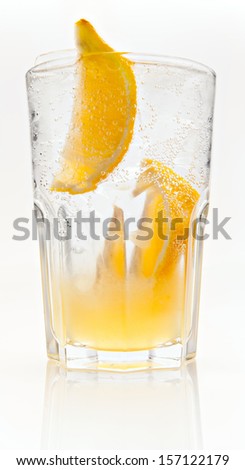 Cocktail with citrus syrup, tonic, slices of lemon and ice on a white background