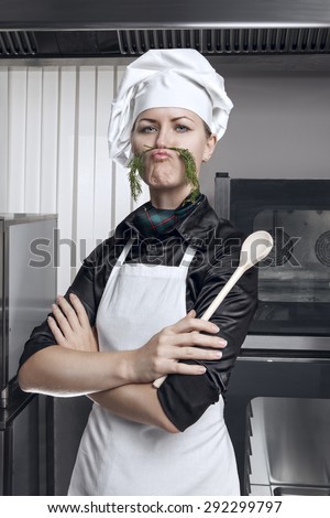 Professional female chef with a mustache of green dill on a professional kitchen