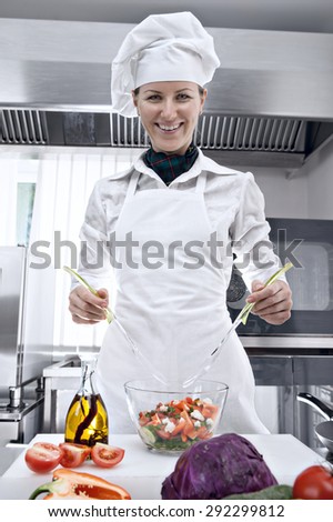 Professional female chef preparing salad in a professional kitchen