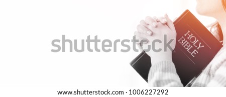 woman praying on holy bible in the morning.teenager woman hand with Bible praying,Hands folded in prayer on a Holy Bible in church concept for faith, spirituality,worship and religion.