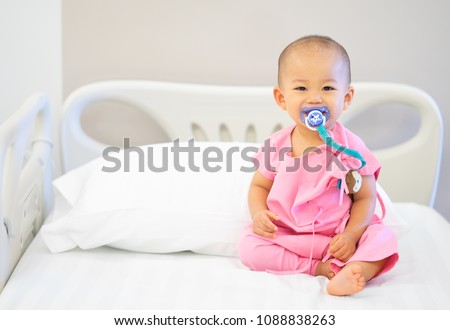 Sick child baby boy lying in bed with a fever in bed at hospital