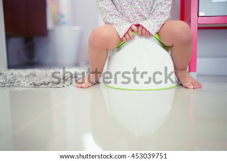 funny child girl sitting on chamberpot, Children\'s legs hanging down from a chamber-pot.