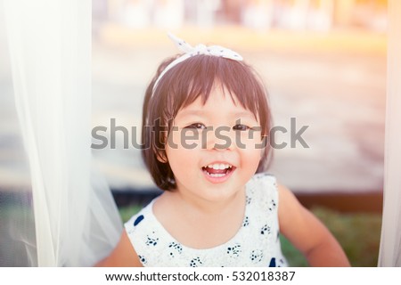 Little girl child showing front teeth with big smile: Healthy happy funny smiling face young adorable lovely female kid with new tooth dental loss: Joyful portrait of asian elementary school student