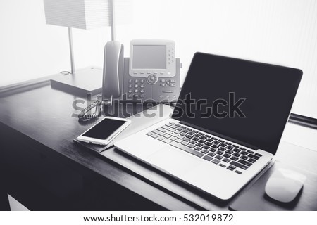 Office desk,Office workplace with laptop and smart phone on wood table.Black and white.