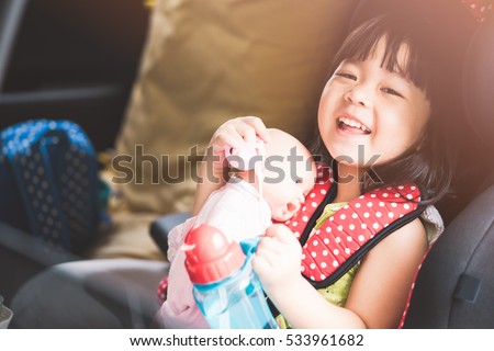 Transport, safety, childhood road trip and people concept - happy little girl sitting in baby car seat, Child in auto baby seat in car, Adorable little girl in the car.