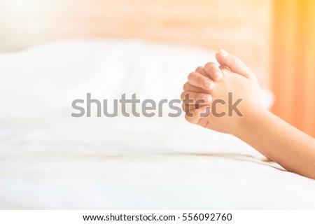 woman praying on the bed in the morning.teenager woman hand with Bible praying,Hands folded in prayer on the bed in the morning concept for faith, spirituality and religion
