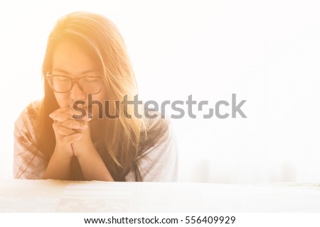 woman praying on the bed in the morning.teenager woman hand praying,Hands folded in prayer on the bed in the morning concept for faith, spirituality and religion