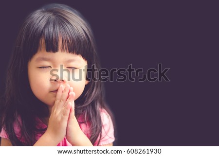 Little girl praying in the morning.Little asian girl hand praying,Hands folded in prayer concept for faith,spirituality and religion.Black background.