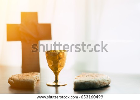 holy communion on wooden table on church.Taking Communion.Cup of glass with red wine, bread and Holy Bible and Cross on wooden table.black and white.