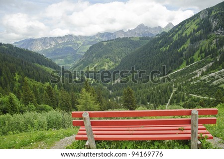 Lonely bench on roadside with beautiful  mountain forest scenery in Austria