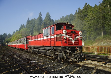 Red train under blue sky on railway forest in Alishan National Scenic Area, Taiwan, Asia.