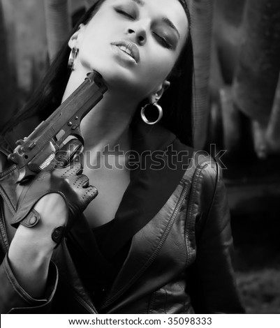 Black and white young woman in leather jacket with gun