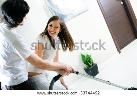 Beautiful girl and boy with vacuum cleaner