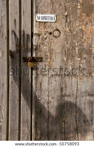 A shadowy figure breaking in to a locked door