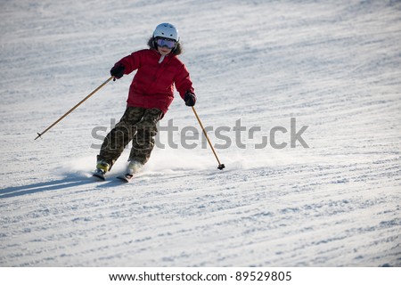 The boy in a red jacket on skis in mountains