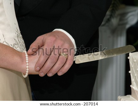 hands cutting wedding cake