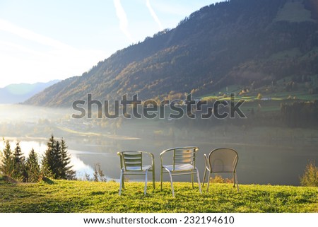 Three chairs at viewpoint in Alps, lake and mountains, Germany