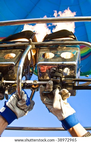 Gas burner for balloon with human hands in gloves