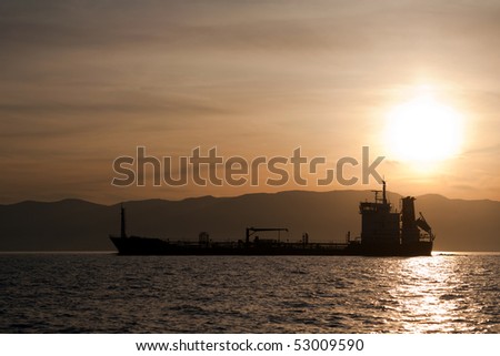 Bulk-carrier ship at sunset in the sea