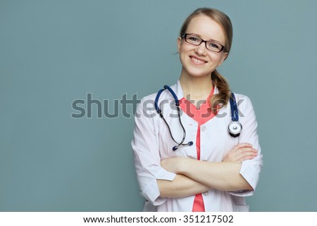 Medical doctor woman with stethoscope white lab coat and glasses on a blue background smiling