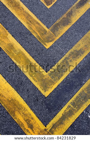 Asphalt road with yellow hazard stripes sign