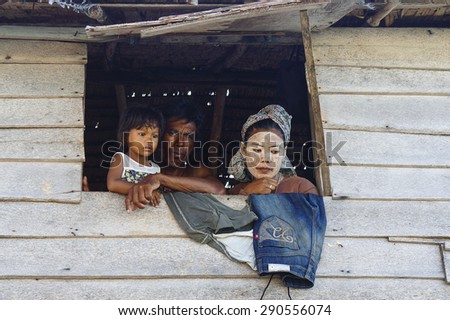 MAIGA ISLAND, MALAYSIA - JUNE 5 : Family of Sea Gypsy (Bajau Laut) at the window of wooden hut on June 5th, 2014 in Maiga Island, Sabah, Malaysia.