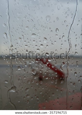 focus of rain drops on airplane window in rainy day before taking off