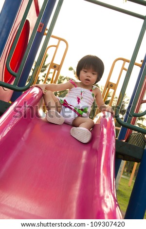 Child plays on slide in an outdoor playground