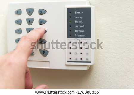 Hand is setting home security alarm system