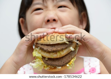 Little girl with big burger or sandwich inside mouth