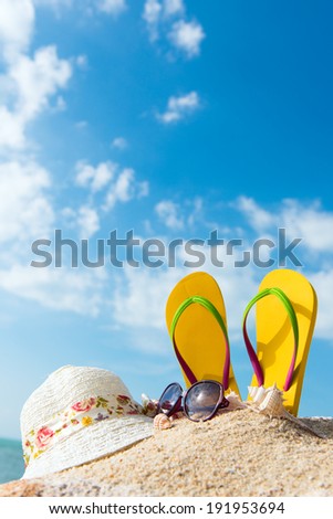 Summer beach vacation concept with flip flop, sunglasses and floppy hat