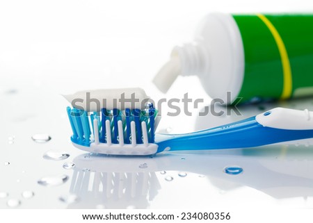 Close up of blue toothbrush and toothpaste tube