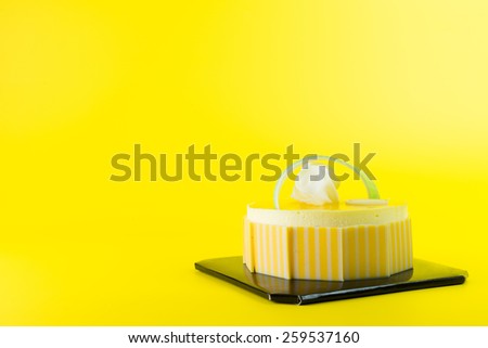 Mango mousse cake isolated on yellow background
