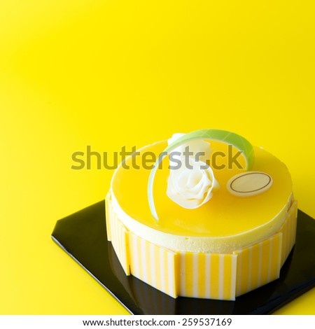 Close up of mango mousse cake on yellow background