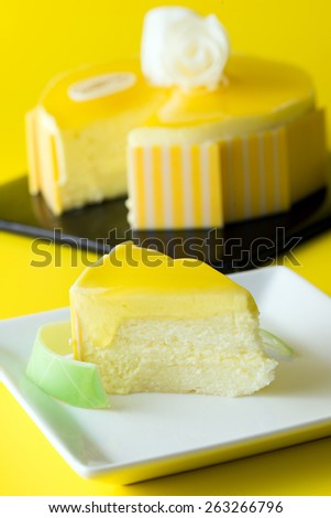 Slice of mango mousse cake served on white plate