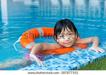 Little Asian girl with orange water ring in swimming pool