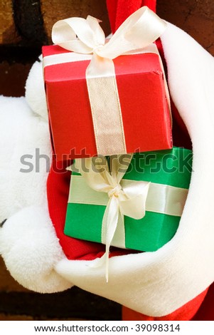 Gift boxes with ribbon in a Christmas sock hanging on fireplace mantel