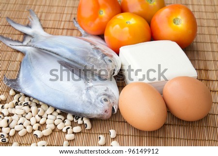 Raw fish with eggs, tofu, black eye beans and tomatoes indicating healthy eating habits