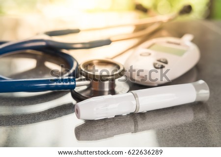 Stethoscope and blood glucose meter, lancet on the wooden table.Health care medical and check up, diabetes, glycemia, and people concept. Flat lay.