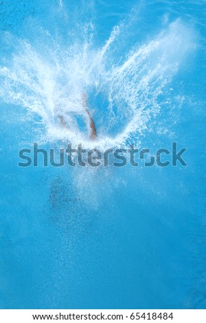 A girl jumps from a diving platform into the pool