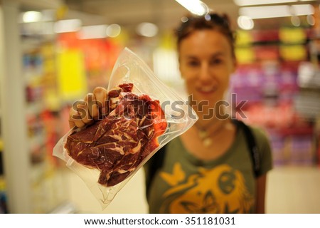 Happy woman holding a bag of vacuumed meat