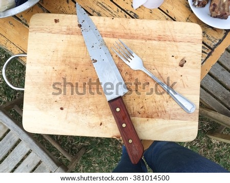 abstract Wooden cutting boards with knives and forks on table , outdoor party