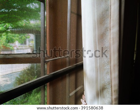 abstract close up part of wooden window and curtain with mosquito wire screen and Curved steel in house