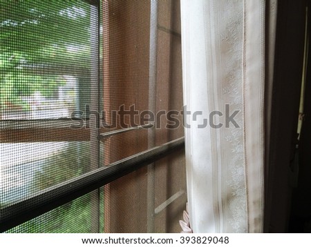 abstract close up part of wooden window and curtain with mosquito wire screen and Curved steel