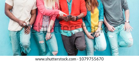 Group of friends watching smart mobile phone - Teenagers addiction to new technology trends - Youth lifestyle, tech, social, millennial generation and friendship concept - Main focus on center hands