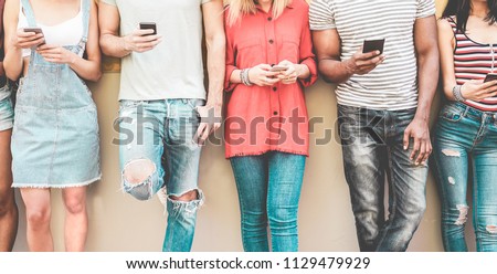 Group of millennial friends watching smart mobile phones - Teenagers addiction to new technology trends - Concept of youth, tech, social and friendship - Focus on smartphones hands
