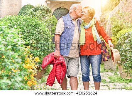 Happy playful senior couple in love tenderly enjoying romantic vacation for wedding anniversary celebration - Joyful elderly active lifestyle - Warm filter with artificial sunlight