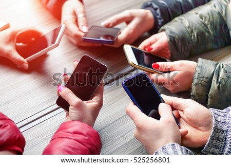 Group of friends having fun together with smartphones - Closeup of hands social networking with mobile smart phone online - Technology and phone addiction concept -Soft focus on right bottom hand