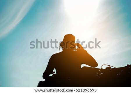 Silhouette of dj mixing outdoor with back sun light - Portrait of disc jockey playing old style vinyl music music for people on beach party at sunset - Fun and ,summer,entertainment and fest concept