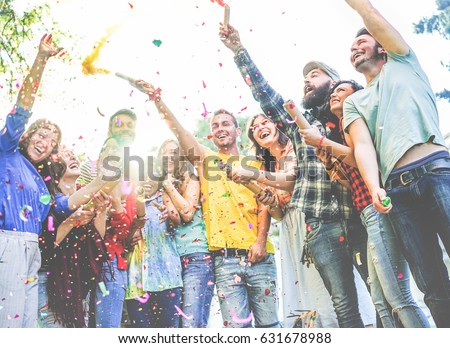 Happy friends enjoying party,throwing confetti and using smoke bombs colors at party outdoor - Young students having fun together - Youth concept - Main focus on two right guys faces - Vintage filter
